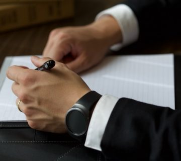 Person on black suit jacket writing on white paper 940829 360x320