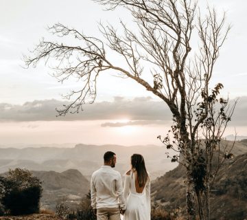 A couple in white dress standing in view of the mountain 2917382 360x320