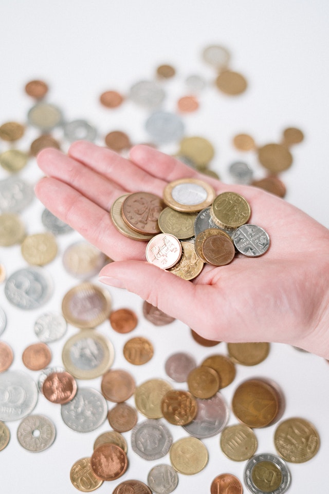 Person holding silver and gold coins 3943722
