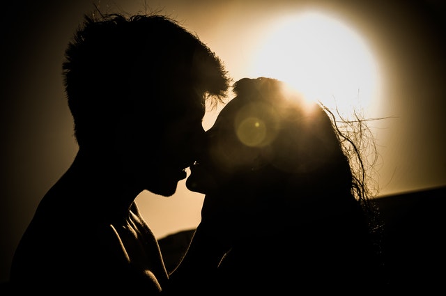 Silhouettes of couple kissing against sunset 41068