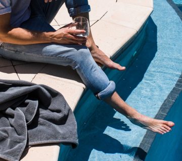 Man in blue polo shirt and blue denim jeans sitting on white 4819833 360x320