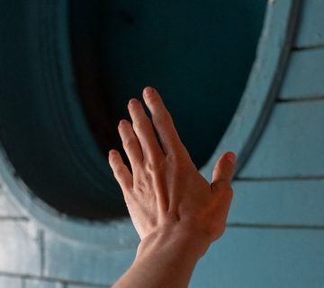 Persons hand on round black wooden window 4760925 360x320