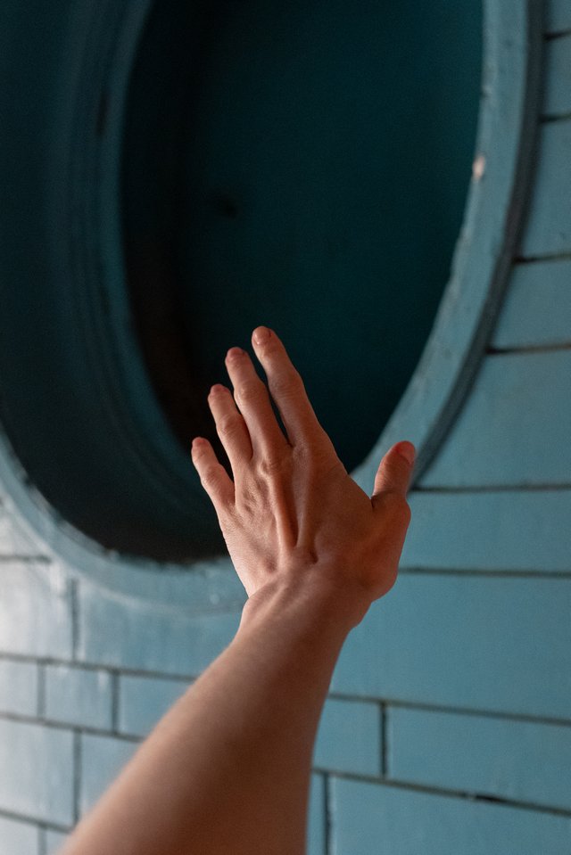 Persons hand on round black wooden window 4760925