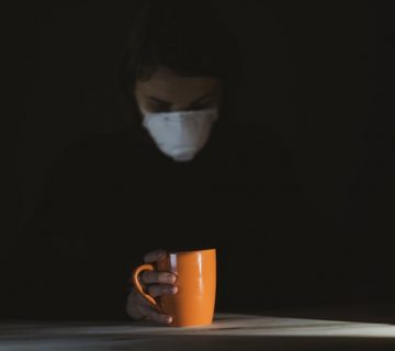 Woman in black shirt holding orange ceramic mug 4056201 360x320