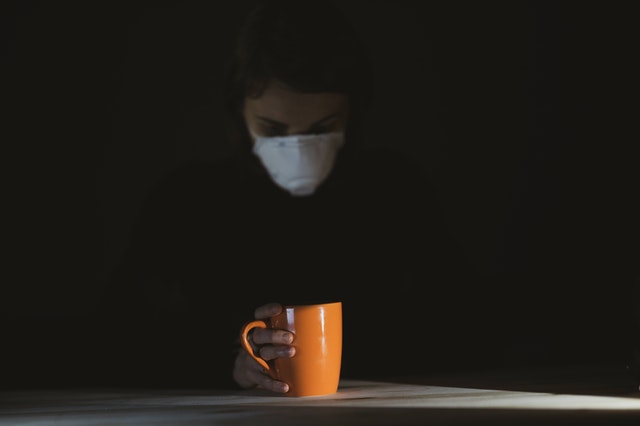 Woman in black shirt holding orange ceramic mug 4056201